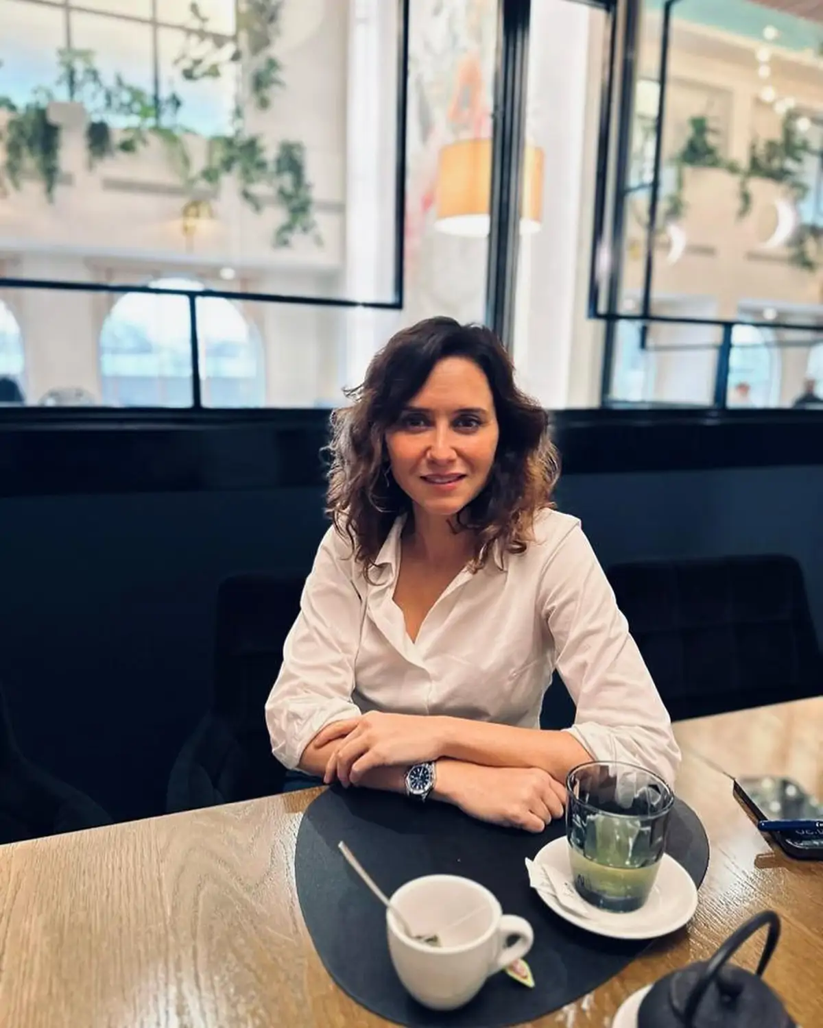 Isabel Díaz Ayuso sentada en una mesa de cafetería